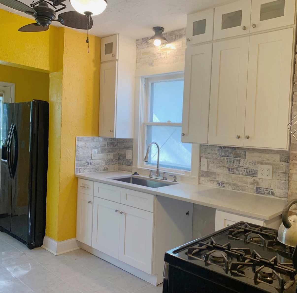 White shaker cabinet kitchen with stone backsplash