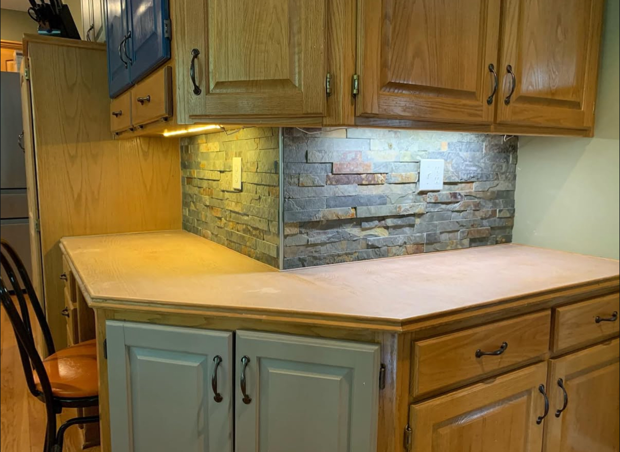 Kitchen with stone backsplash and oak cabinets